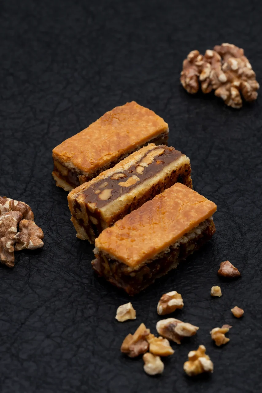 クルミとキャラメルをサクサクの生地で挟んだ焼き菓子「KURUMERU」の商品写真。