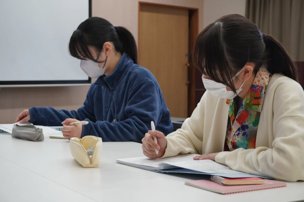 真剣な表情で資料を読み込み、ノートにペンを走らせる二人の新採用職員