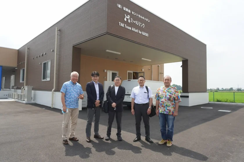 セントラルキッチン「ミールリンク」の建物前で記念撮影をする社会医療法人北斗の皆様と征峯会スタッフ