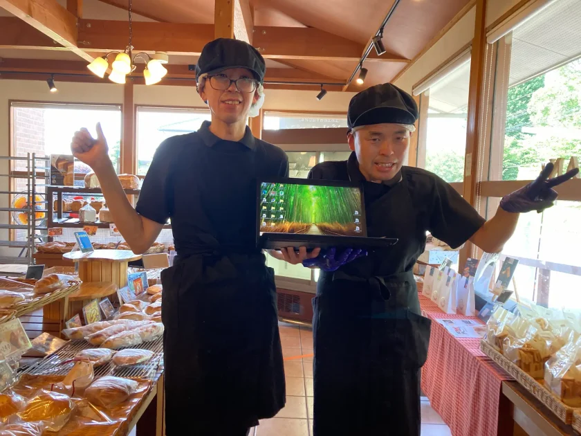 購入したパソコンを持ち、笑顔でポーズをとるCAFEラパンのスタッフ2名