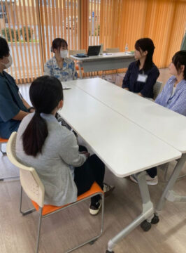 テーブルを囲んで談笑する学生と先輩職員