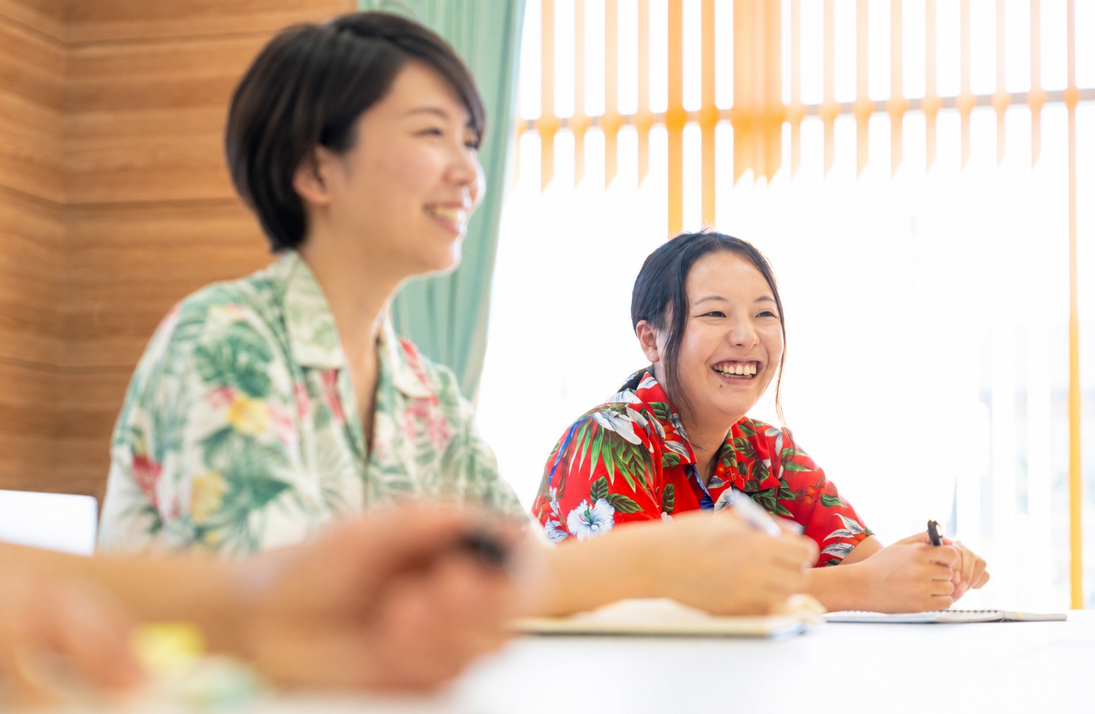 アロハシャツの制服で、和やかな雰囲気の会議。